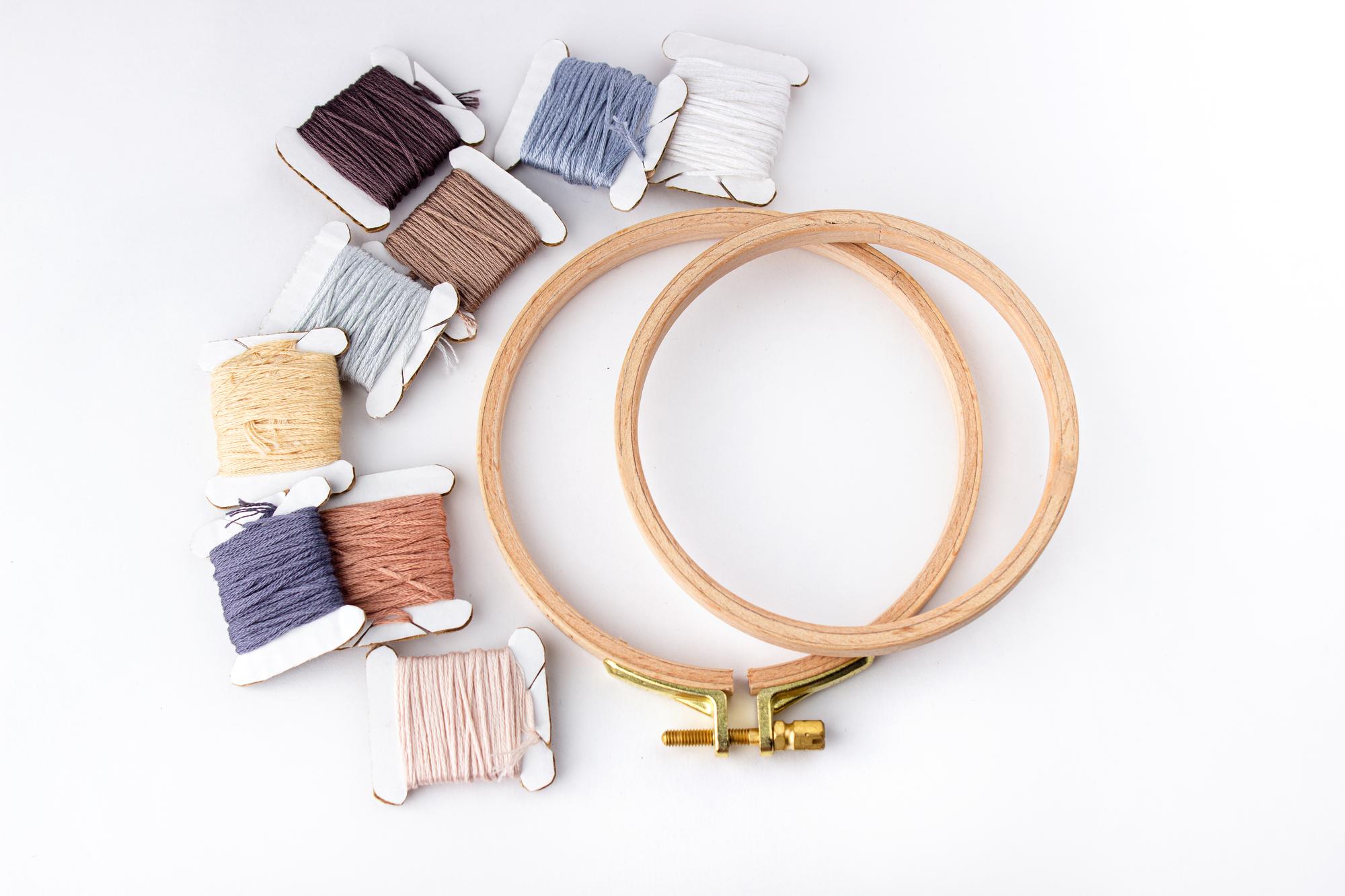 Studio workspace with embroidery hoops and threads